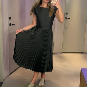 Mörkgrön klänning H&M - Mörkgrön klänning av finare kvalitet från H&M, satin-liknande material. Använd en gång. Strl 34