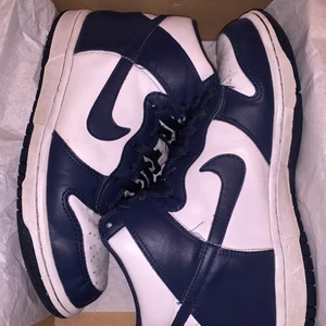 NIKE DUNK MIDNIGHT NAVY - Tjena säljer mina Nike Dunk High Midnight Navy som är använda i typ 4 månader! Storlek 39. De är köpta på footlocker och kvitto finns. Jättebra skick inga defekter förutom lite creases som ändå blir på alla skor! 