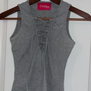 Grå topp med snörning  - Grå topp med snörning framtill från Diabless i storlek xs/s