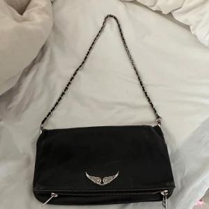 Zadig Voltaire väska - Zadig voltaire väska i den stora modellen. Säljer för att den tyvärr inte kommer till användning. Jag har både ett längre band och en dustbag till❤️ Köpt för 4500 kr ungefär, den är ganska använd därav det ganska mycket sänkta priser, har tyvärr inte kvitt