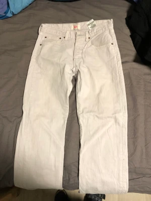 Levis jeans  - Ett par vita Levis jeans, tyvärr en liten röd fläck på benet där bak som jag inte får bort. 