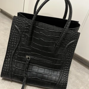 Handväska svart - En rymlig handväska i svart färg.  Bredd ca 30 cm och höjd ca 30 cm.  Oanvänd.  Köparen betalar för frakten.  Celiné Paris, FAKE!