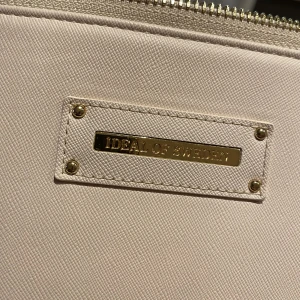 Datorfodral  - Beige/ljusrosa datorfodral med gulddetaljer från Ideal of sweden. Har nån liten repa. Passar bra för 13/14 tum datorer (ex MacBook Air). Nypris 599kr.