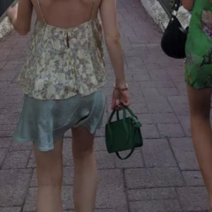 Väska Zara - Söt liten väska från Zara. Medföljer en guldig kedja och en annan liten grön ”miniväska” som går att hänga på. Går att ha crossbody med det långa bandet.