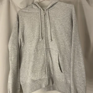 Zip hoodie - Grå Basic siphoodie från H&M. Använd fåtal gånger men är i nyskick. Storlek M. Nypris 199kr säljes för 100kr. Köparen står för frakt 