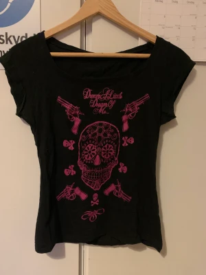 T-shirt med rosa dödskalle - T-shirt med rosa dödskalle och text.