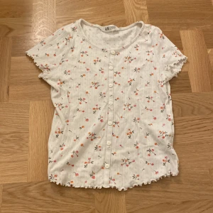 Blommig tröja  - Söt blommig tröja med knappar, bra kvalite och bekväm. 30kr + frakt