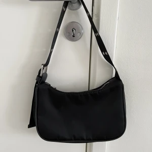 Svart baguetteväska - Säljer denna svarta baguetteväska. Det har skavs bort lite silvrig färg från dragkedjan (se bild), annars i fint skick. 