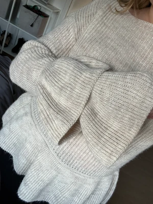 Stickad tröja - Stickad beige tröja med ballongärmar och båthalsringning. Storlek M men kan funka till en L med beroende på hur man vill den ska sitta