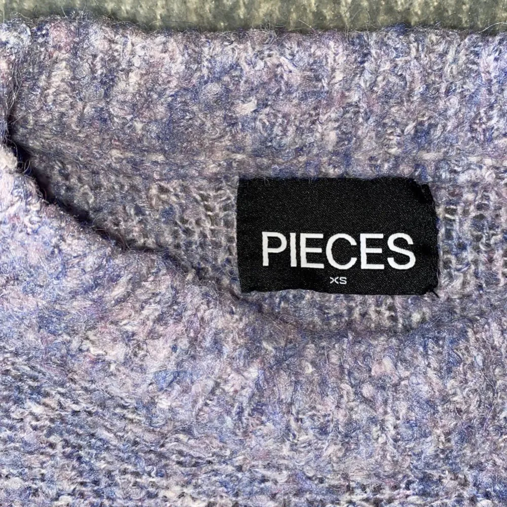 Säljer denna lila/blå stickade tröjan från Pieces då den inte kommer till användning längre. Tröjan är lite ”cropad” i modellen men passar mig som vanligtvis har storlek S.. Stickat.