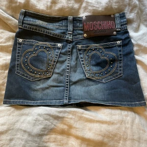 Vintage Moschino Kjol - Moschino-kjolen är vintage. Jag kan inte ta hand om den så det är därför jag säljer den, och har aldrig använt den.  Midjemått: ca 77 cm längdmätning: ca 35 cm