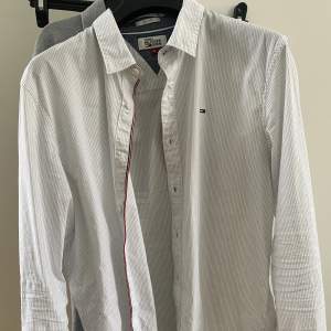 Säljer vit randig, Tommy Hilfiger skjorta som ej används. Storleken är M/L typ. Köpt för 799kr säljer för 349kr. Inga defekter men använd, Cond 8/10
