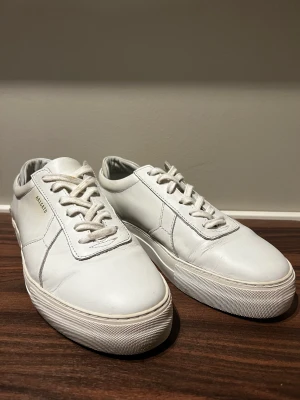 Vita sneakers från Arigato - Snygga vita sneakers från Axel Arigato. Använda men fortfarande i okej skick!  Nypris ca 2000kr