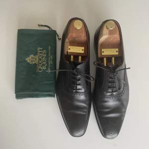 Elegant semibrogue på läst 348, som är lite spetsig och lätt mejslad. Vidd E (Standard). UK10,5/44,5-45. Högsta kvalitet. Lagt på en tunn slitsula i gummi. Liten skrapning vid höger häl (bild 3). Annars i nyskick! Nypris 6400 kr.   OBS! Skoblock ingår ej!