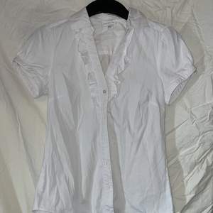 Så söt och fin vit skjorta! Har en volang vid kragen och den är fint figursyddd! 