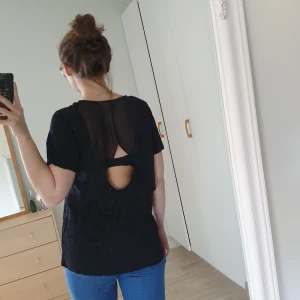 Svart fin t-shirt - T-shirt med meshtyg på överdelen av ryggen med hål i ryggen. L men passar även M