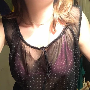 meshlinne - väldigt genomskinligt. prickigt. jag har använt det med nåt färggrant linne under. ganska y2k. avklippt nedtill! jättefint. justerbar i halsen!! man kan knyta banden dom hänger ner på första bilden tajtare eller lösare eller ta ut dom