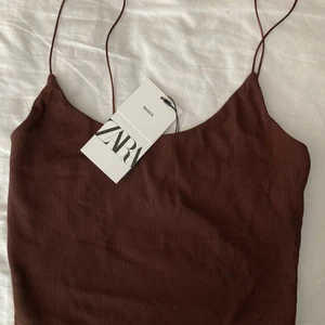 Brun topp från zara - Jag köpte denna fina oanvända topp från Zara förra sommaren, men har aldrig använt den då den var lite stor på mig. Den är brun och väldigt stretchig i materialet. Buda från 40 kr. Skriv privat för fler bilder och vid andra frågor! Köparen står för frakt.