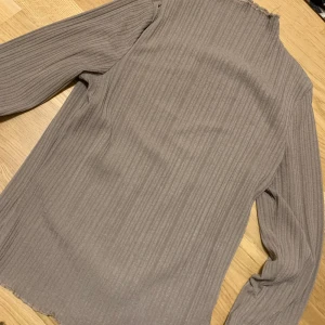 Tröja  - Fin och stilren tröja i färgen beige, köpt för något år sen, den sitter tight på kroppen och formar den fint.