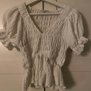 Topp från Chiquelle  - Vit fin topp från Chiquelle, har en jättefin passform. Lite v-ringad och superskönt material.  