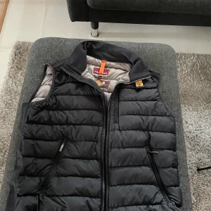 Parajumper väst - En fin parajumper väst, hyffsat använd men ändå i fint skick. Den har dock tappat fordring lägre ner på ryggen. Men annars en mycket fin väst! Storlek L som ni ser på bilden. Skriv till mig privat angående prisförändring.