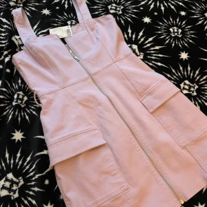 Helt oanvänd jeansklännkng! - Säljer denna jättefina klänning i stretchigt jeansmaterial pga fel storlek. Lappen sitter kvar, och klänningen har insydda öglor för att stylas med ett snyggt midjebälte och även fickor!! Nypris: 249 kr 