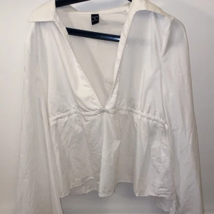 Snygg blus  - Snygg vit blus som går att knyta på sidorna och har vida armar, använd 1 gång 