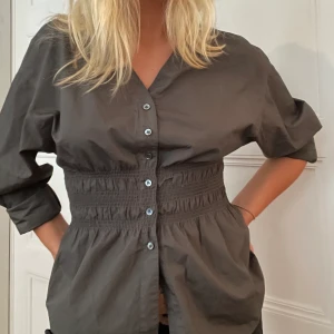 Topp - Supersöt top som markerar midjan jättefint! Säljer för 300kr och den är i storlek M! Den kommer ifrån Arket! 