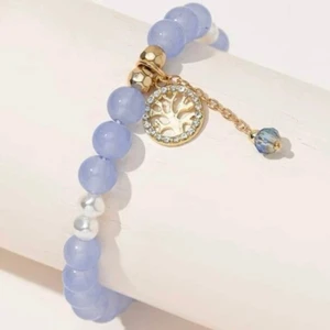 ARMBAND BLÅ PÄRLOR GULD TRÄD - Pärlarmband i ljusblått. Frakt 14kr. Filmar när paketet packas och lämnas till ombud/brevlåda. SAMFRAKTAR