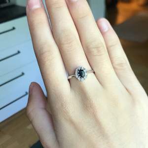 Säljer denna vackra ring som har en äkta safir i 0,7 karat samt tio diamanter runt. Ringen är i silver och inköpt på albrekts guld. Kvalitetsintyg ingår såklart! Ringen är i storlek 19. Säljer då den tyvärr är lite för stor. Mycket fint skick!