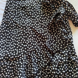 Sommar kjol💕 - Väldigt fin svart kjol med blommor, har resårband på baksidan av midjan och en snörning att knyta som önskat med! 