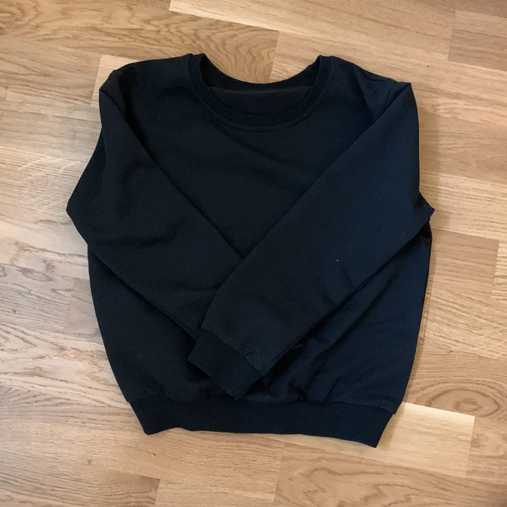 En svart tröja som jag säljer för att den är för liten . Hoodies.