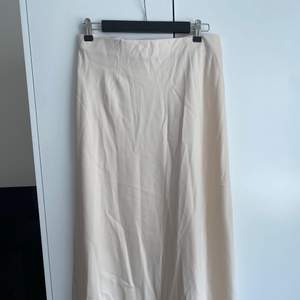Midi kjol i beige satin från bikbok. Aldrig använd. 