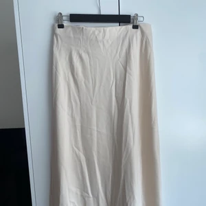 Satin Midi kjol - Midi kjol i beige satin från bikbok. Aldrig använd. 