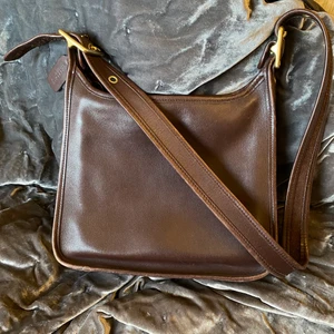 Coach Väska - Säljer min snygga vintage Coach Väska. Kan justeras i längden och är i fint skick. Köptes second hand. Fler bilder kan ordnas om så önskas. Brunt läder, gulddetaljer. Hör av er vid frågor! 