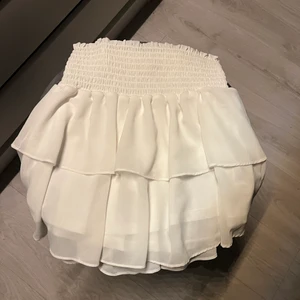 Vit volangkjol  - Säljer denna superfina Chelsea kjolen i vit då den inte längre kommer till användning. Endast använd en gång därav i mycket bra!! skick. Perfekt kjol till sommaren❣️❣️Bud 300+frakt. Köp direkt 320+frakt!!