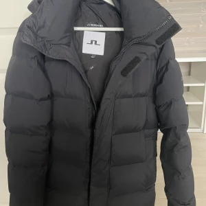 J.Lindberg Vinterjacka - Väldigt stilren J.Lindberg vinterjacka som är 1 vinter gammal. Den är inte använd mycket alls och är en perfekt vinterjacka. Håller värmen jätte bra och har en perfekt passform. 