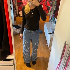 Jeans med smileys  - Baggy jeans med smileys på, byxorna är i xs och för mig som brukar ha xs/s så är de lite stora i midjan! Använda ca 10 ggr men bra skick!! 