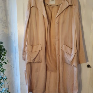 Kappa Rosa/Beige Storlek 42 - Rosa/Beige kappa i ett fallande, tunt tyg. Knappt använd och i fint skick.