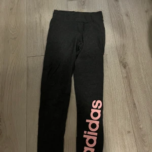 Adidas tights - säljer ett par adidas tights i jättefint skick, supersköna och stretchiga, grå med rosa text