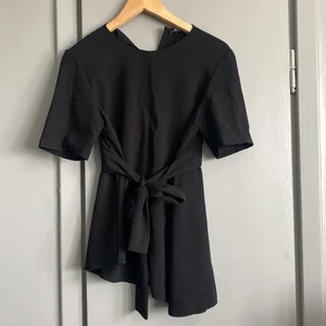 Blus - Svart blus med knytning i midjan. Stl M