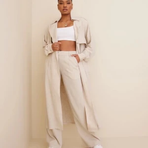 NLY trend Linen Trench Coat - Trenchcoat från NLY Trend Slag vid halsringningen Lång ärm med en manschett med en knapp vid ärmsluten Bälte i midjan Nyskick Nypris 999kr