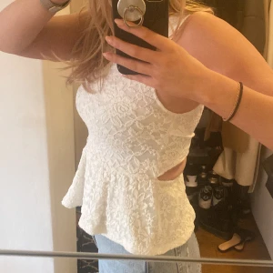 Vit topp med mönster  - Söt topp med blommigt mönster med öppen rygg från BikBok. Strl XS. 