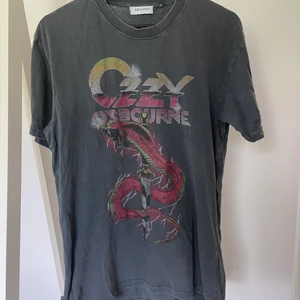Ozzy Osbourne Band t-shirt  - En cool band t-shirt med ingen mindre än Ozzy! Knappt använd, därav vecken från att ha legat i garderoben. Perfekt längd om man vill knyta den. Rak i passform och Inte allt för oversized.