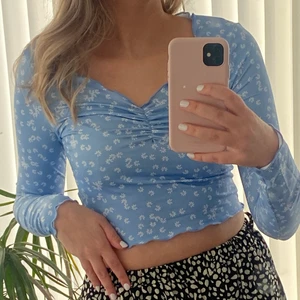 Blå blommig topp 💙 - En blå fin somrig topp med blommor på💙 Storlek S. Aldrig använd. Skulle beskriva materialet som lite ”baddräktsmaterial” ifrån Shein