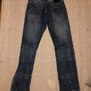 Ett par Frank Q low rise jeans med jättenajs tvätt på benen