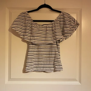 Off shoulder, randig sommar topp - Vit och svart randig sommartopp, den går perfekt att ha den som off shoulder men man kan även ta upp den på axlarna. Skönt och mjukt material och perfekt för sommaren.