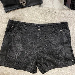 Shorts  - Väldigt trendiga och snygga relativt lågmidjade ”djur” skinns shorts med läder och nitar detaljer på sidorna. De är i storlek L men passar mig som är S i vanliga fall