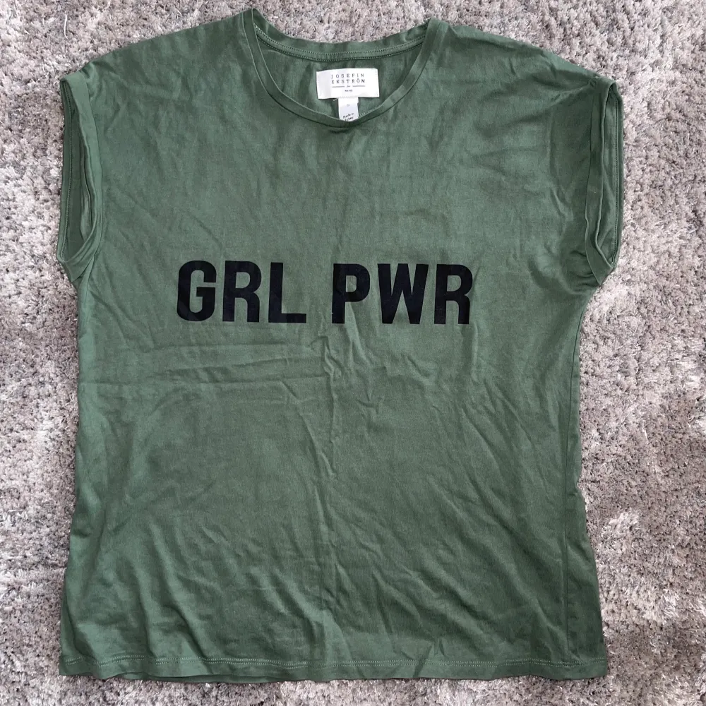 Cool militärgrön linne/T-shirt med girl power tryck. Nästan oanvänd och alltså i toppskick. Köparen står för frakten 💕. Skjortor.