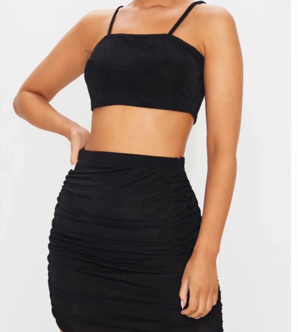 New with tags. Black Strappy Crop And Ruched Midi Skirt Set  Featuring a strappy crop top and skirt both in a black material. Polyester elastane blend.  Brand new item. Made in UK. Happy to bundle. Will gladly take more pics. Smoke and pet free storage space. No other flaws to note.. Kjolar.
